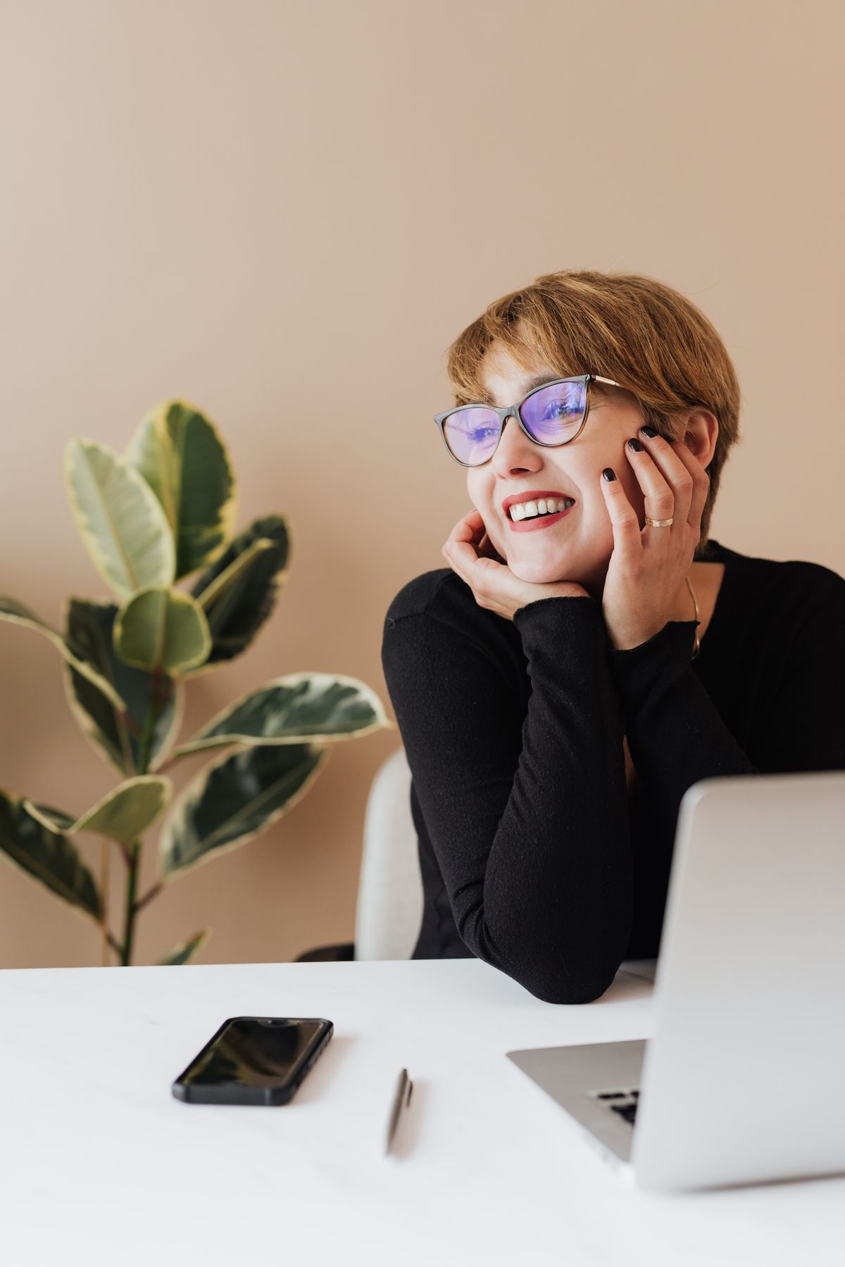 A professional at her laptop in a bright workspace.